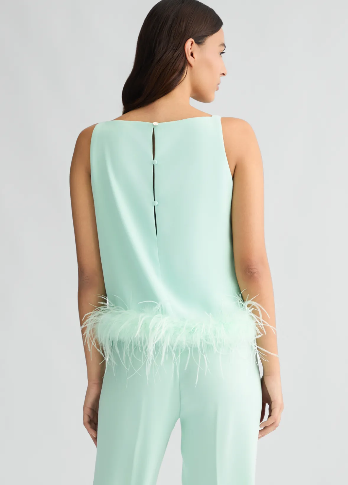 Top elegante con piume